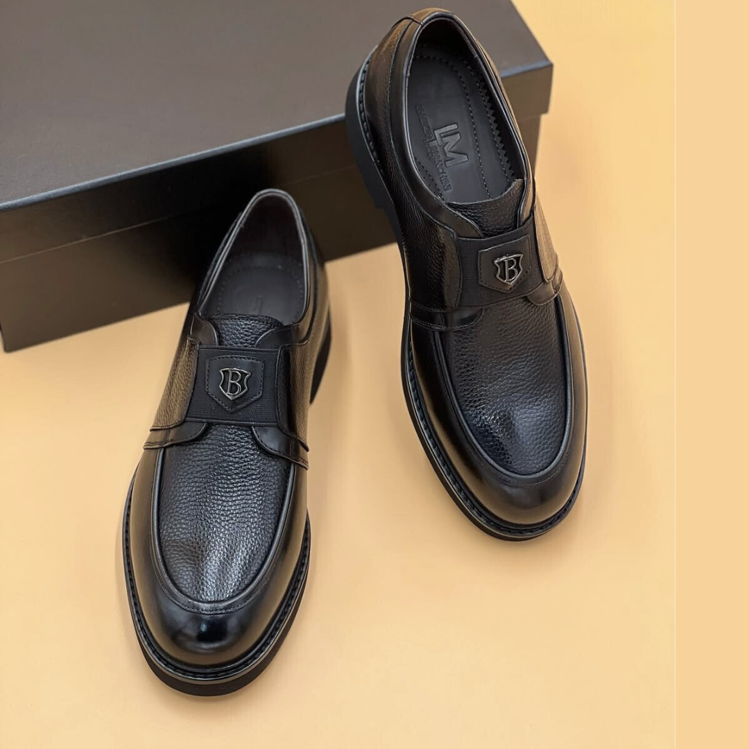 Mocassin Nevisse Signature – Élégance en cuir noir avec emblème métallique