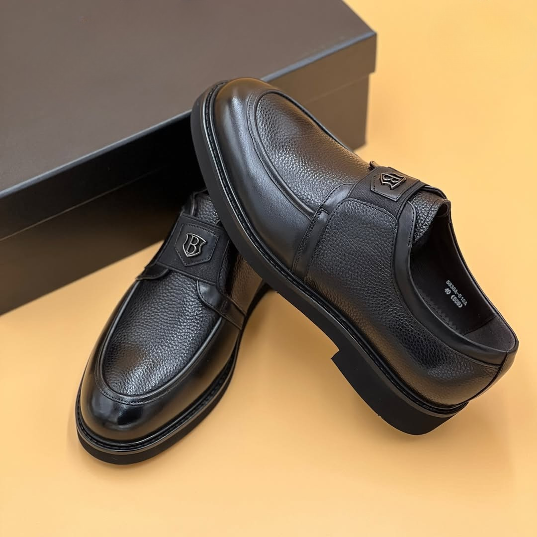 Mocassin Nevisse Signature – Élégance en cuir noir avec emblème métallique