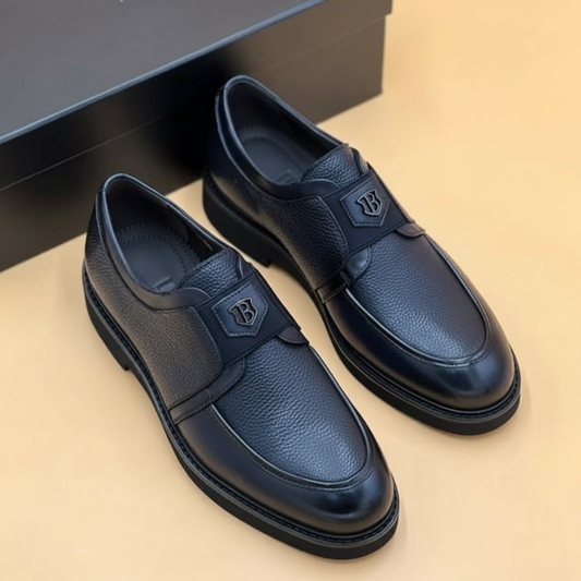 Mocassin Nevisse Signature – Élégance en cuir noir avec emblème métallique